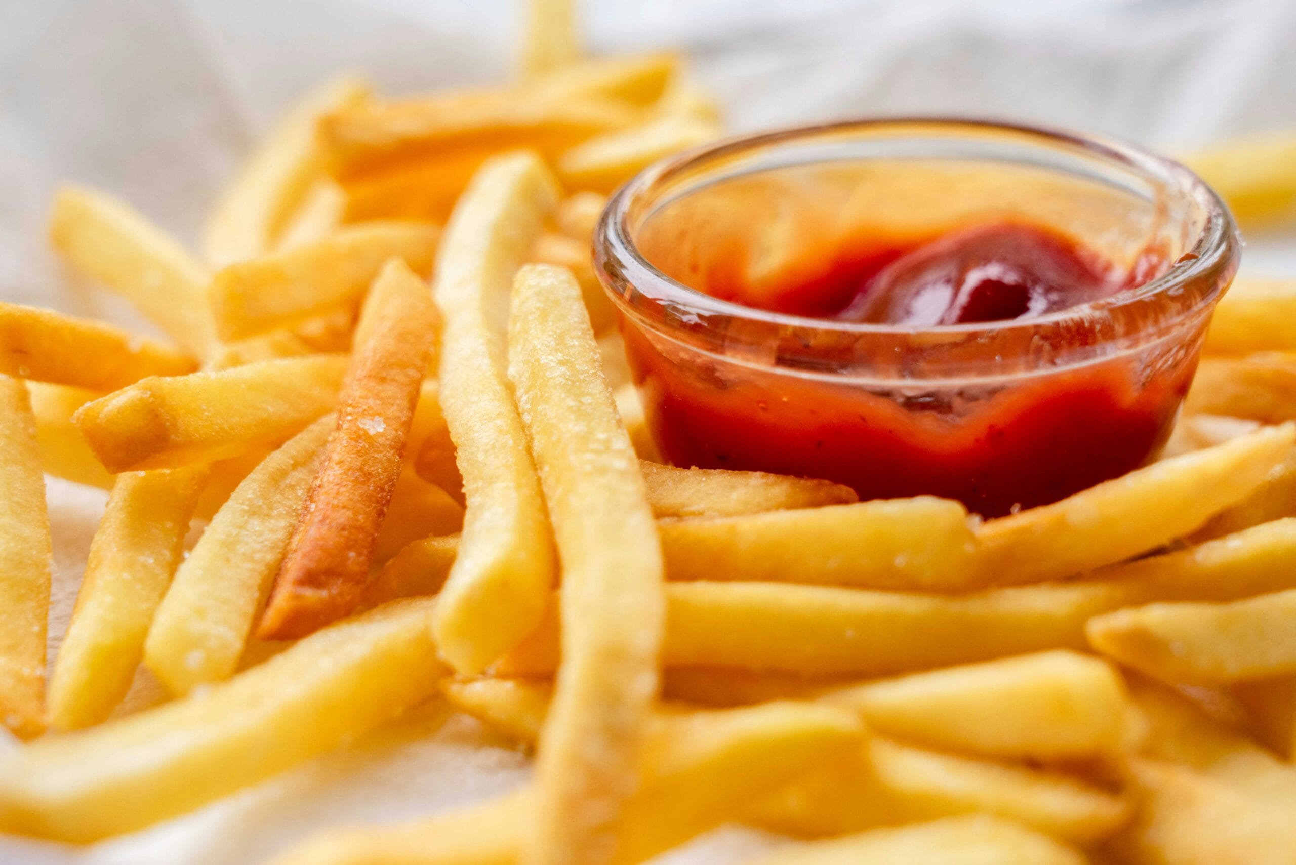 pexels photo 12548553 12548553 Close-up of crispy French fries served with a bowl of ketchup for dipping.