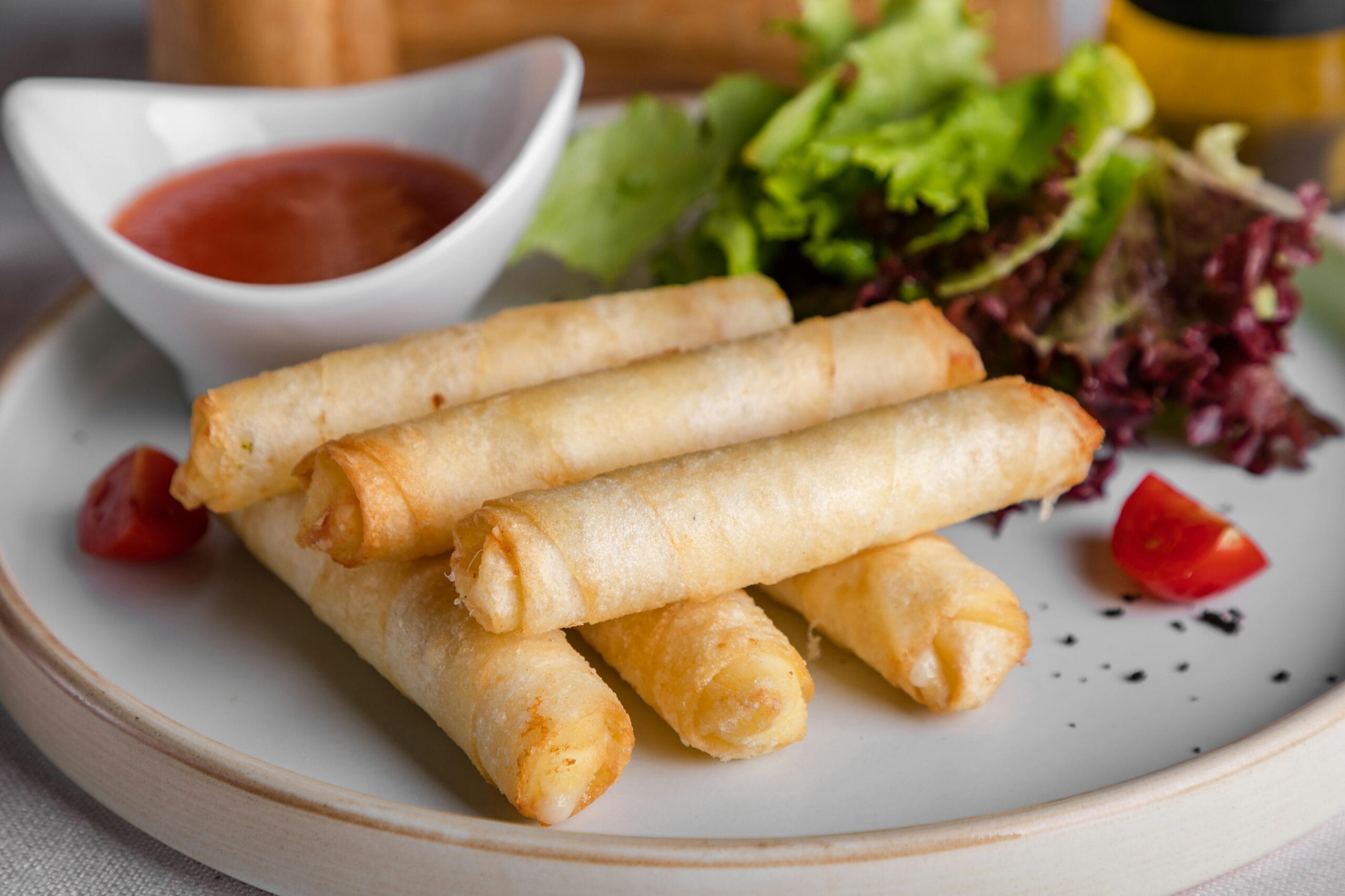 pexels photo 4001867 4001867 Delicious crispy spring rolls served with a side of fresh lettuce and dipping sauce.